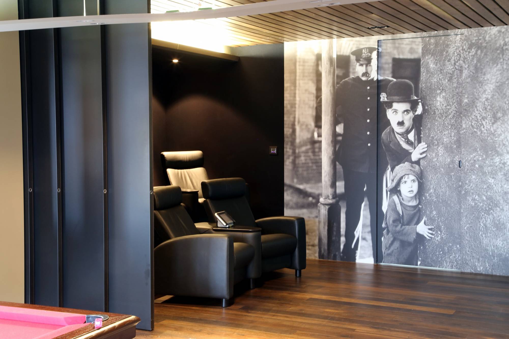 Réalisation de salle de cinéma privée sur mesure ouverte sur salle billard à Paris